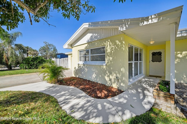 view of side of home featuring fence and stucco siding