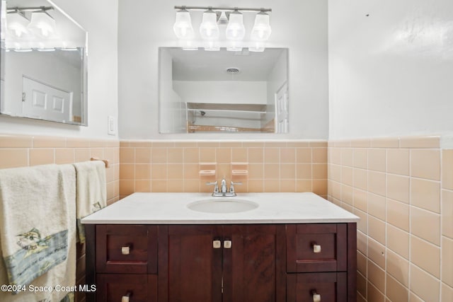 bathroom featuring vanity and tile walls