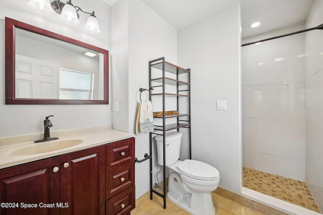 bathroom featuring tile patterned flooring, vanity, toilet, and tiled shower