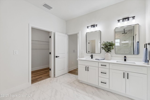 bathroom featuring walk in shower and vanity