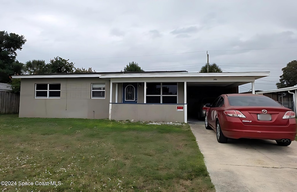 view of front of property with a carport and a front lawn