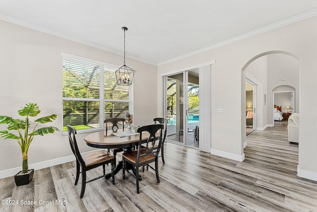 dining space with hardwood / wood-style flooring, a notable chandelier, and ornamental molding