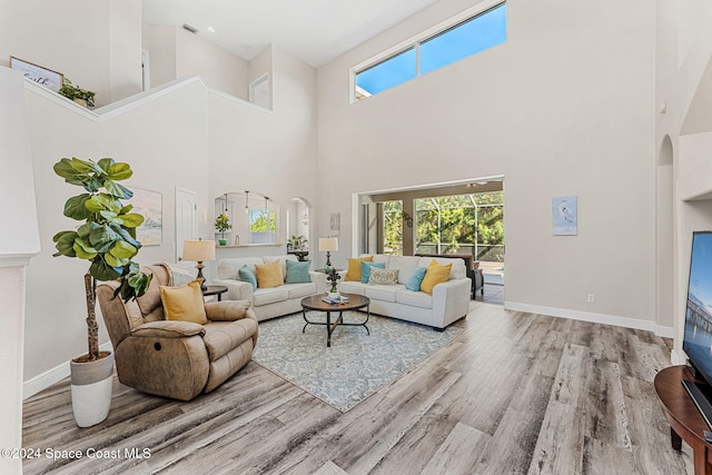 living room with a high ceiling and hardwood / wood-style flooring