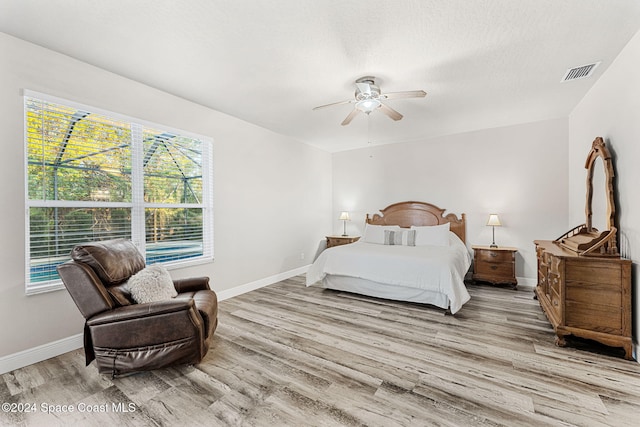 bedroom featuring a textured ceiling, light hardwood / wood-style flooring, and ceiling fan