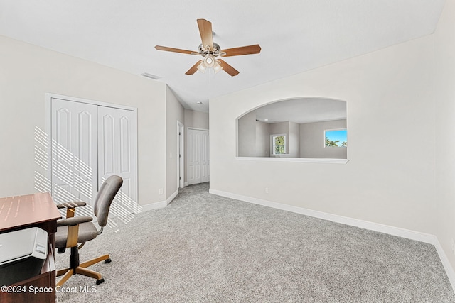 carpeted office space featuring ceiling fan