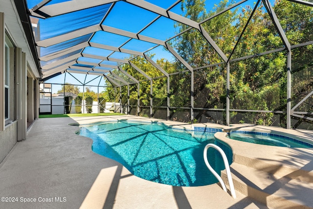 view of pool featuring a lanai, a patio area, and an in ground hot tub