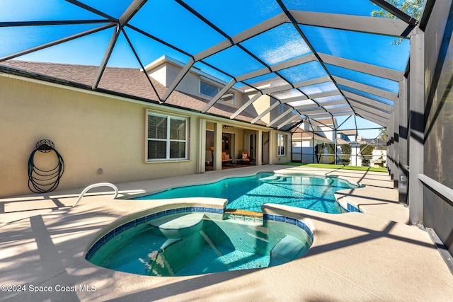 view of pool with a lanai, a patio area, and an in ground hot tub