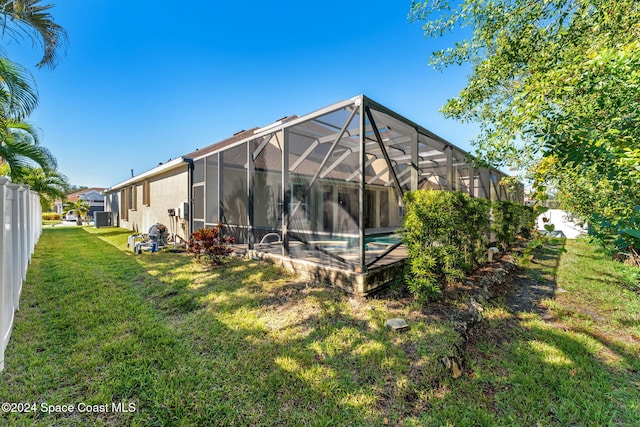 rear view of property with a yard and a lanai