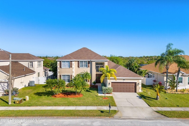 view of front of home with a garage, a front lawn, and cooling unit