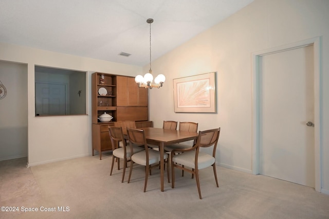 dining area with light colored carpet, vaulted ceiling, and an inviting chandelier