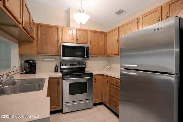 kitchen with pendant lighting, sink, stainless steel appliances, and lofted ceiling