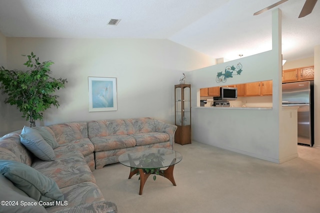 carpeted living room featuring ceiling fan and lofted ceiling