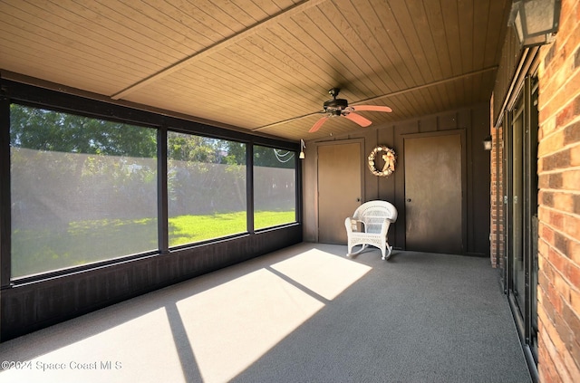 unfurnished sunroom featuring ceiling fan and wooden ceiling