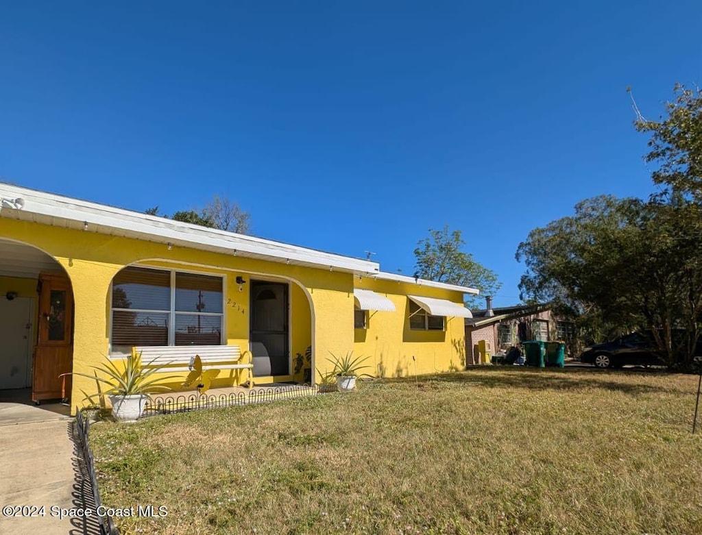 view of front of house featuring a front lawn and a carport