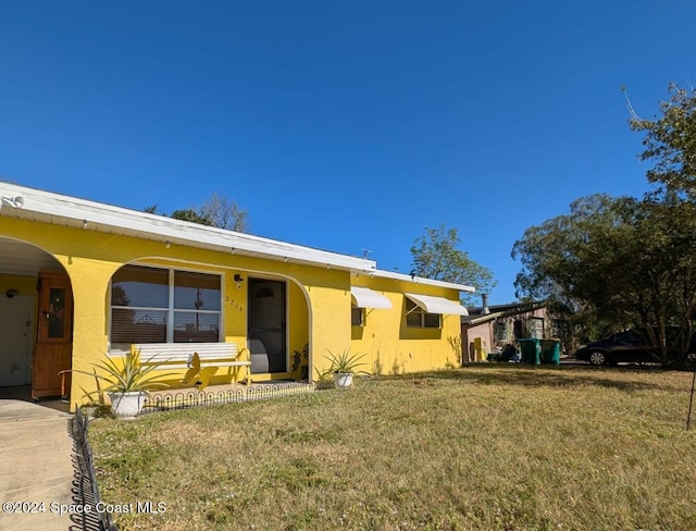 view of front of house featuring a front lawn and a carport