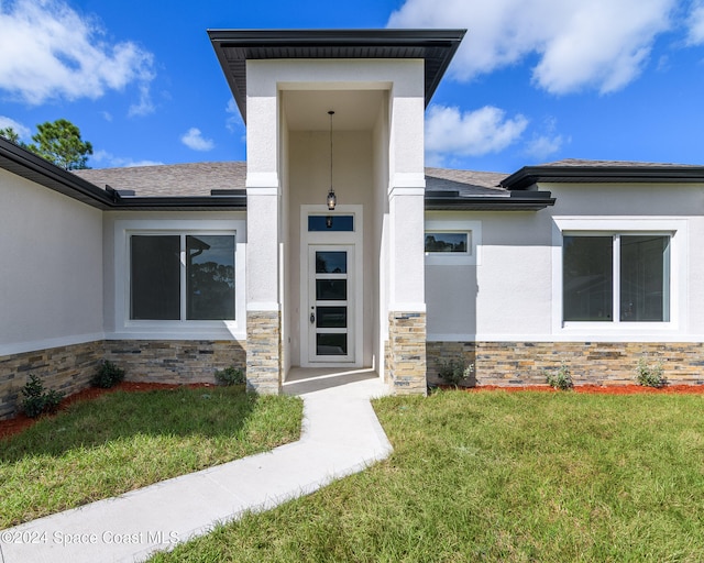 view of exterior entry featuring a yard