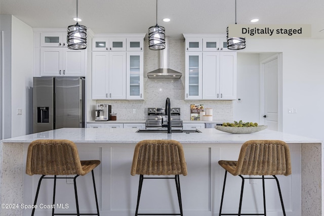 kitchen with decorative light fixtures, a kitchen island with sink, and appliances with stainless steel finishes