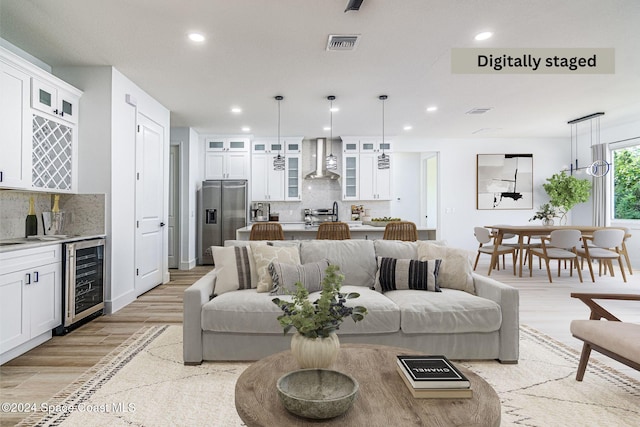 living room featuring wine cooler, indoor bar, and light wood-type flooring