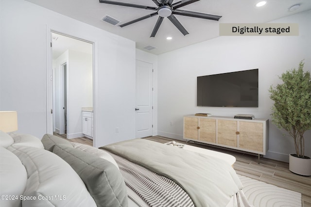 bedroom featuring ceiling fan, light wood-type flooring, and ensuite bath