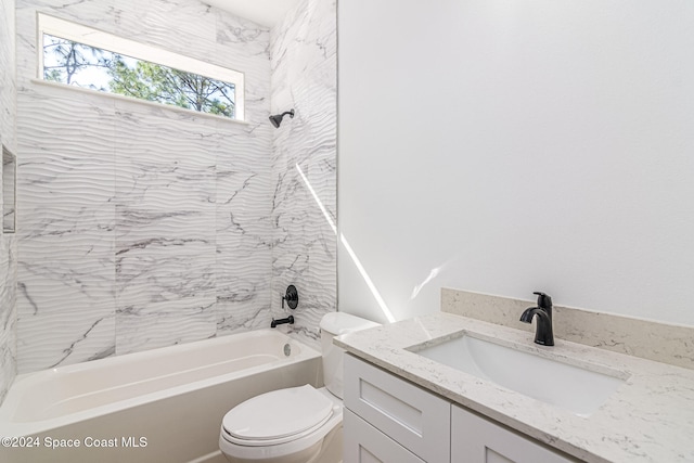 full bathroom with tiled shower / bath, vanity, and toilet