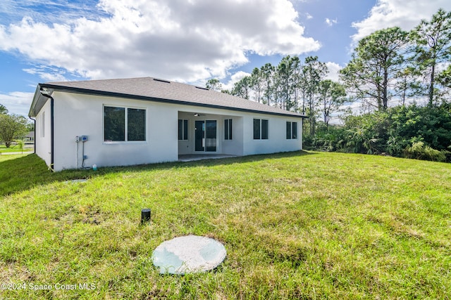 back of house with ceiling fan, a yard, and a patio