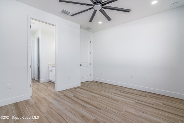 unfurnished bedroom featuring light wood-type flooring, ensuite bath, and ceiling fan