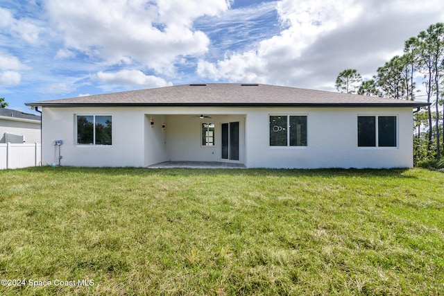 rear view of property featuring a patio area, ceiling fan, and a yard