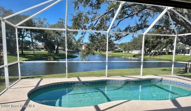 view of pool featuring a lanai, a patio area, a water view, and a yard