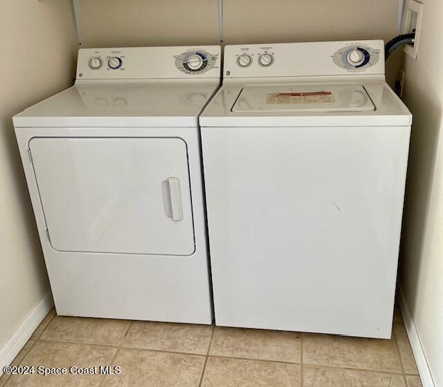 washroom with independent washer and dryer and light tile patterned flooring