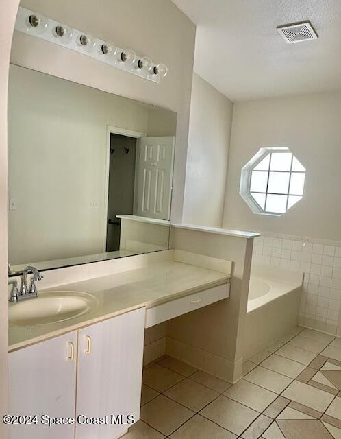 bathroom featuring tile patterned flooring, vanity, tile walls, and a bathing tub