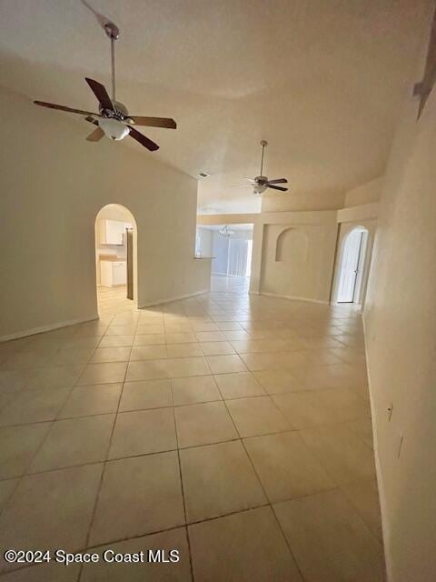 tiled spare room featuring vaulted ceiling and ceiling fan