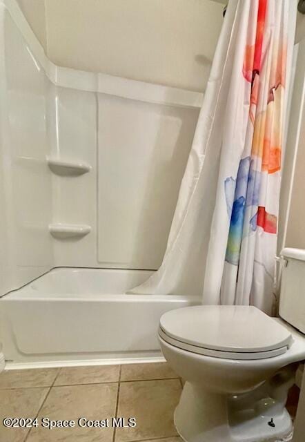 bathroom featuring tile patterned flooring, shower / tub combo, and toilet