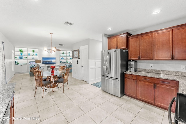 kitchen featuring a notable chandelier, light stone counters, stainless steel fridge with ice dispenser, and light tile patterned floors