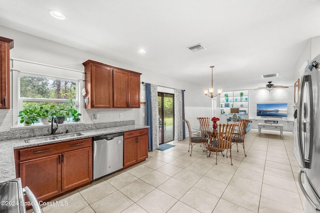 kitchen featuring plenty of natural light, sink, light stone countertops, and stainless steel appliances