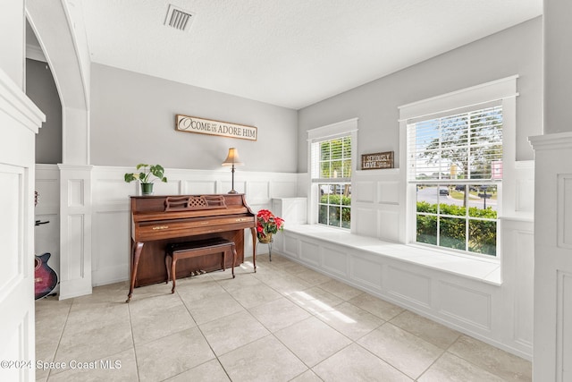 miscellaneous room with light tile patterned flooring and a textured ceiling