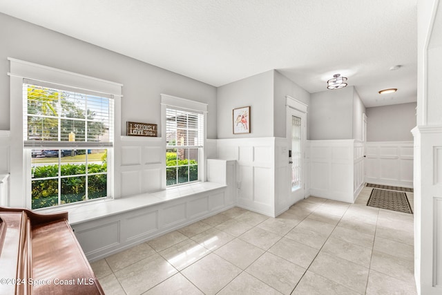 bathroom featuring a wealth of natural light, tile patterned flooring, and a textured ceiling