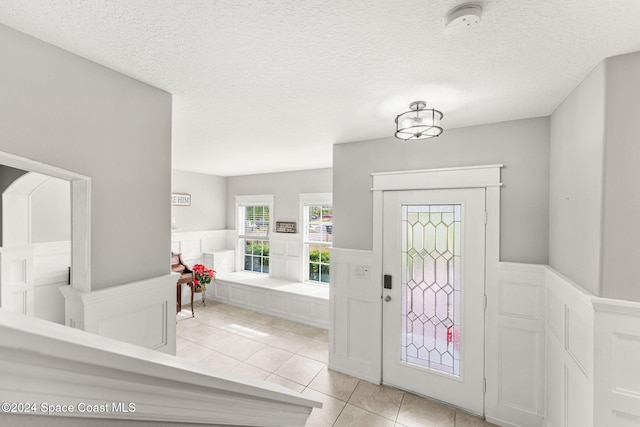 tiled foyer featuring a textured ceiling