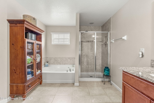 bathroom featuring tile patterned flooring, vanity, a textured ceiling, and plus walk in shower