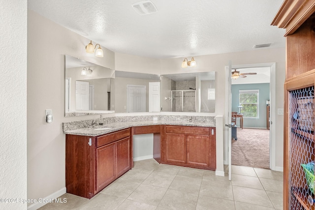 bathroom with tile patterned flooring, an enclosed shower, and a textured ceiling