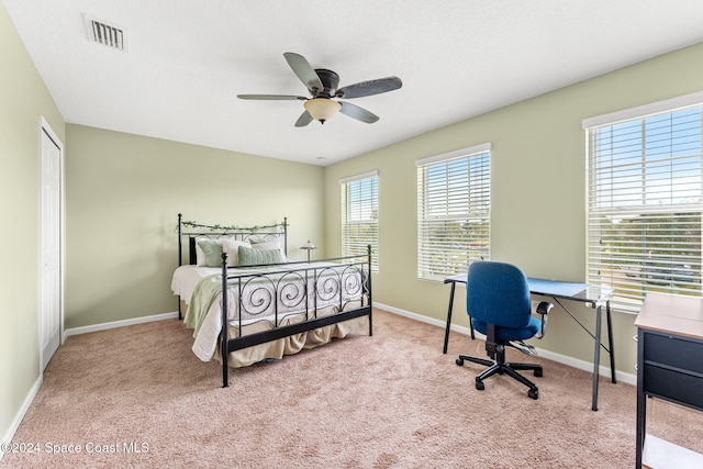 carpeted bedroom with ceiling fan and a closet