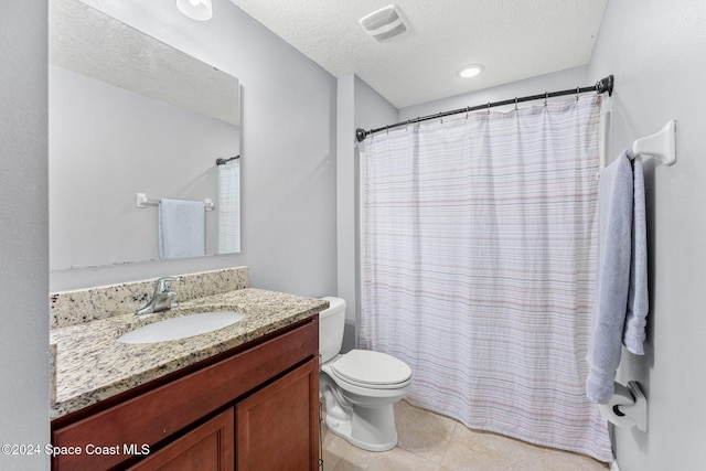 bathroom featuring tile patterned flooring, vanity, a textured ceiling, and toilet