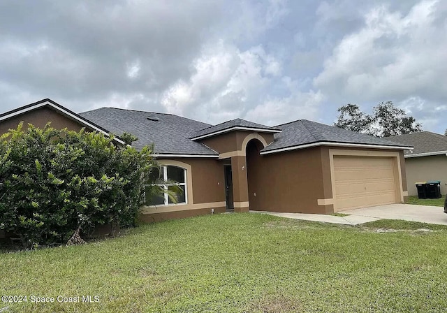 view of front of property with a front yard and a garage