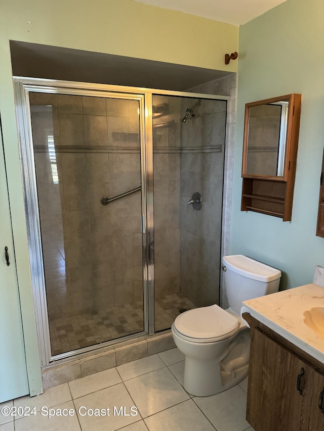 bathroom with tile patterned flooring, vanity, toilet, and walk in shower