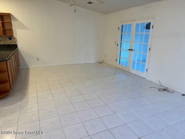 spare room with light tile patterned floors and french doors