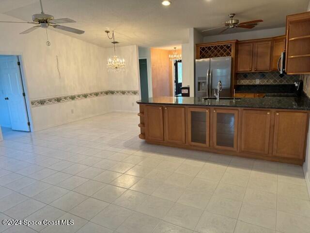 kitchen with sink, hanging light fixtures, light tile patterned floors, kitchen peninsula, and stainless steel appliances