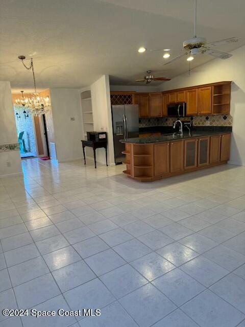 kitchen with decorative backsplash, pendant lighting, stainless steel appliances, and light tile patterned floors