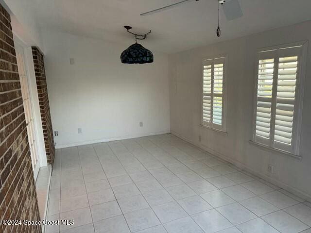 unfurnished room with light tile patterned floors and ceiling fan