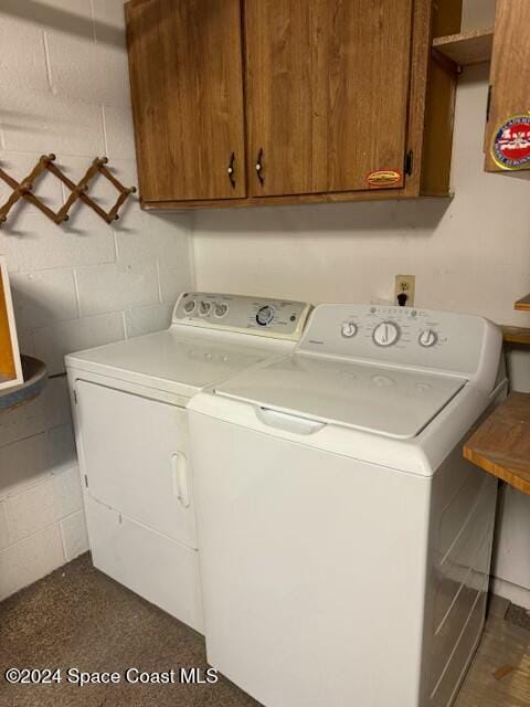 clothes washing area featuring cabinets and independent washer and dryer