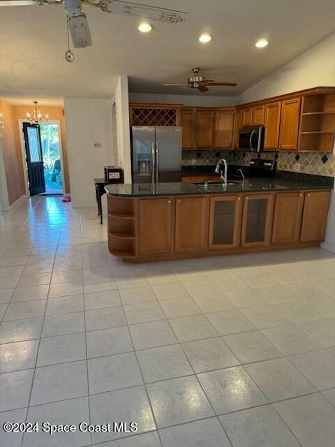 kitchen featuring tasteful backsplash, sink, light tile patterned floors, and appliances with stainless steel finishes