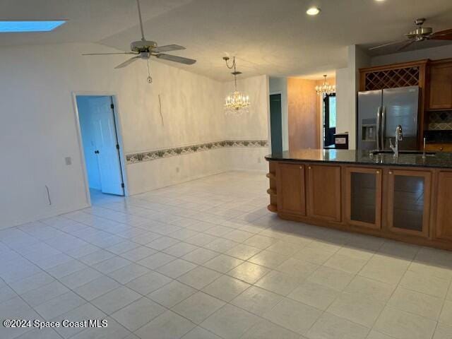 kitchen featuring pendant lighting, ceiling fan with notable chandelier, light tile patterned floors, and stainless steel refrigerator with ice dispenser